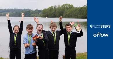 The image shows a group of school students with a prize. There are two logos on the side, eFlow and Engineer Ireland STEPS.