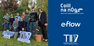 The image shows a group of people including school students and teachers standing in a green outdoor space. The group is holding two sign boards which are logos of eFlow and TII. 